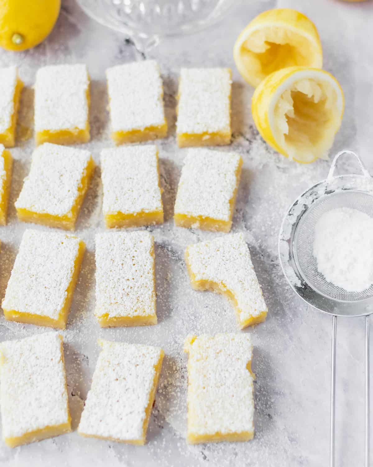 Several lemon bars spread out on a table.