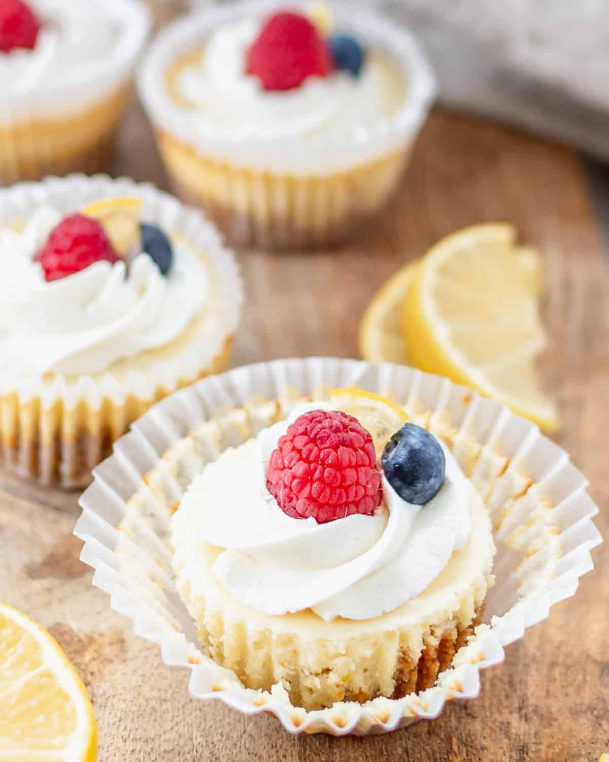 Raspberry and whipped cream on a mini lemon cheesecake.