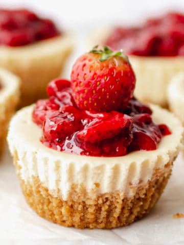 A close up of a mini strawberry cheesecake.