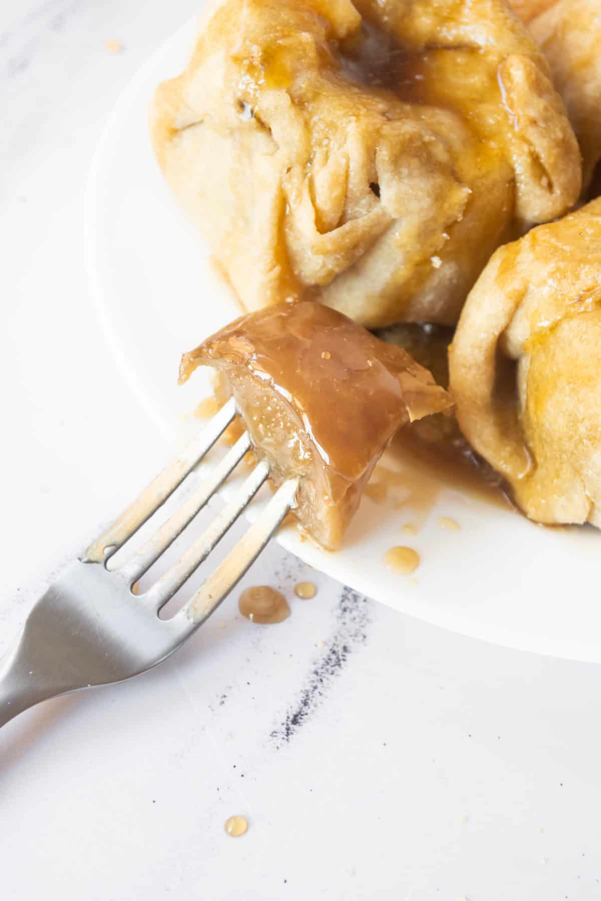Old fashioned apple dumplings on a plate with a fork.