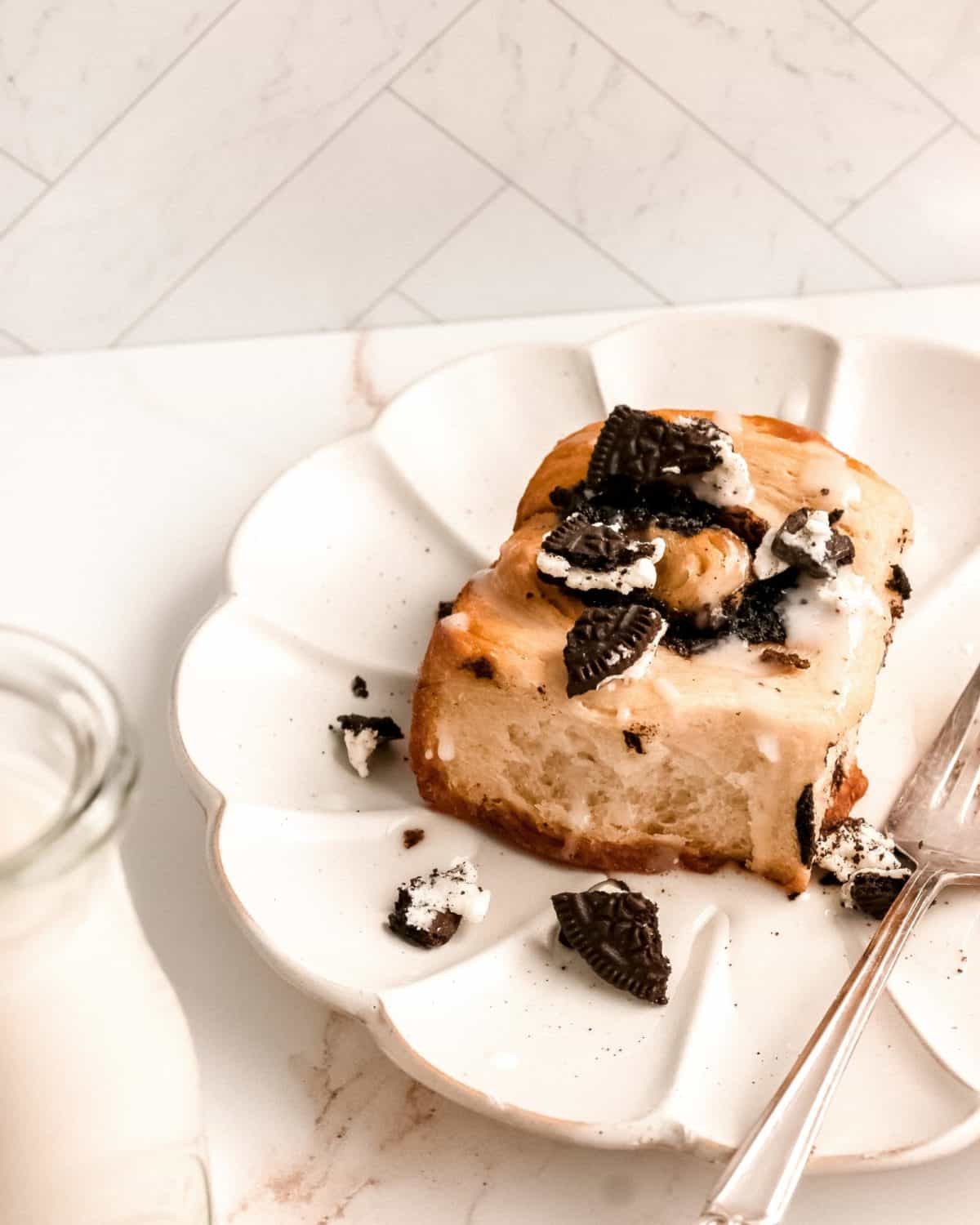 A white plate and fork with a slice of Oreo cinnamon rolls.