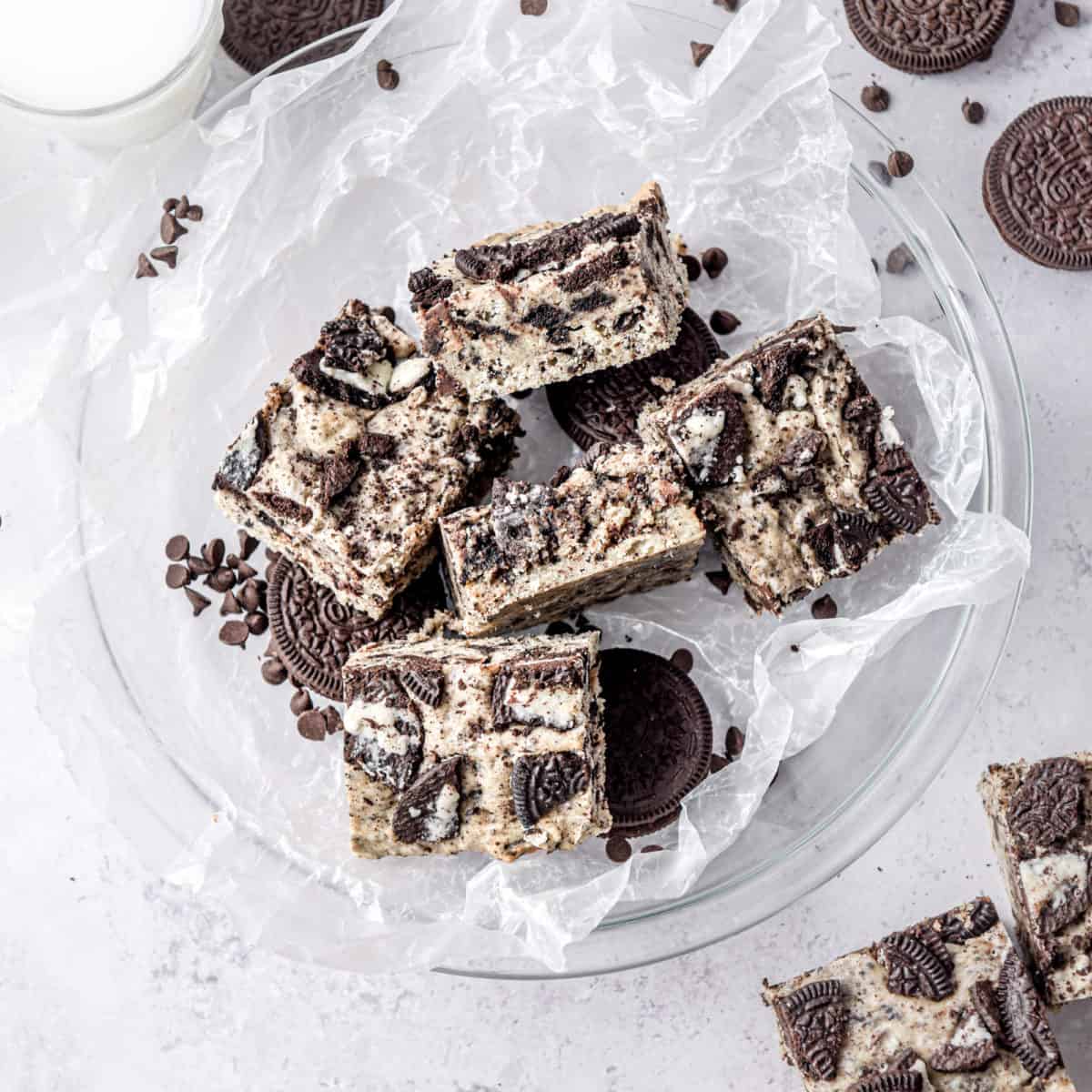 Creamy cookie bars in a bowl surrounded by Oreo cookies.