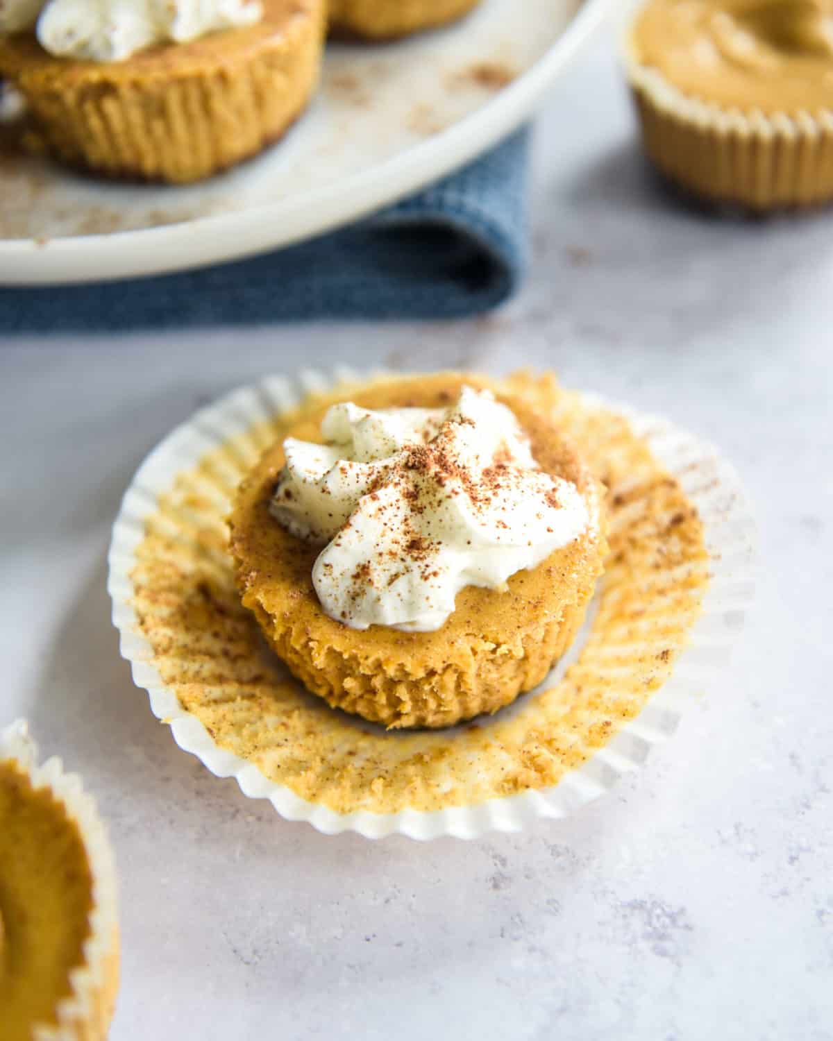An overhead shot of mini pumpkin cheesecake topped with whipped cream.