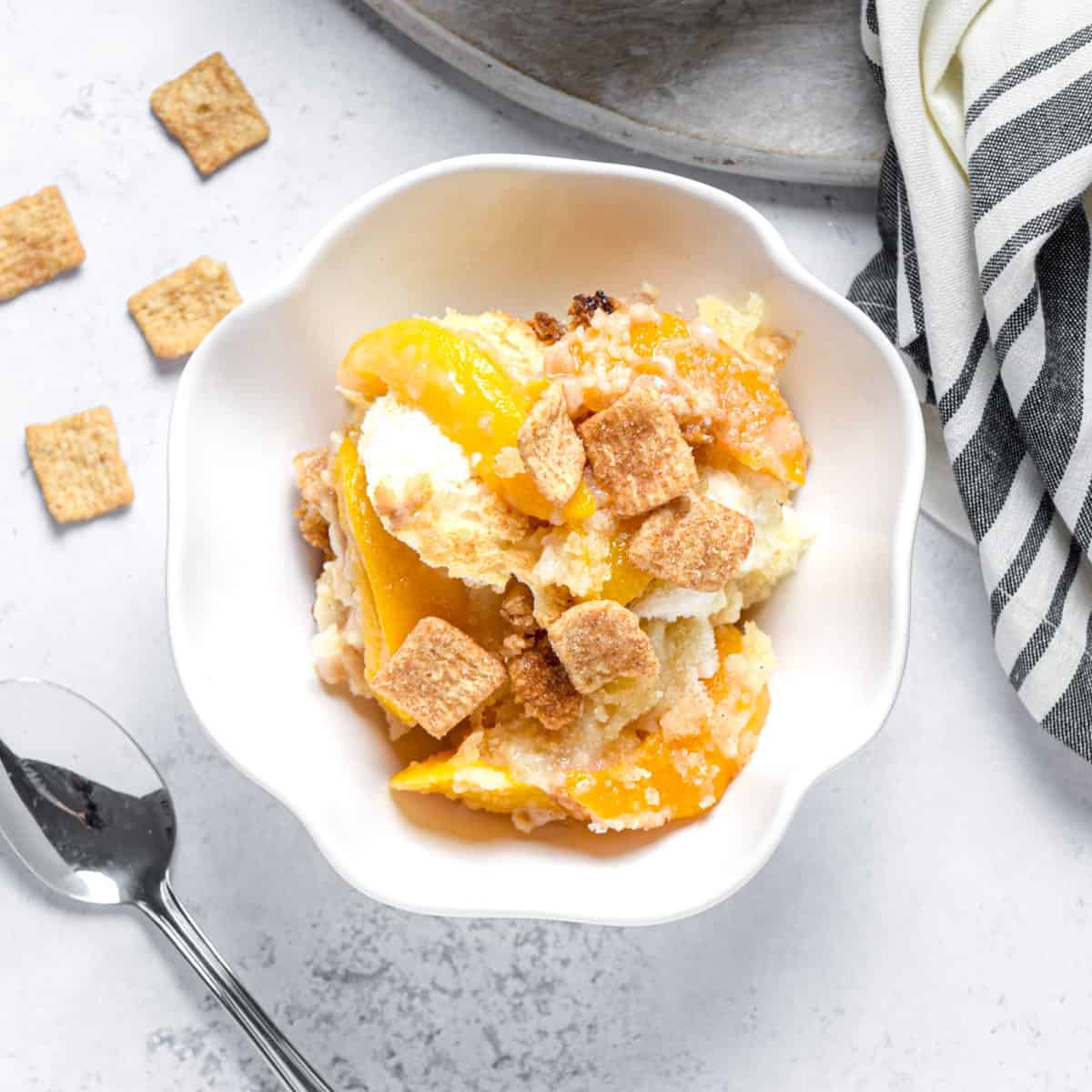 Peach cobbler in a bowl with Cinnamon Toast Crunch cereal.