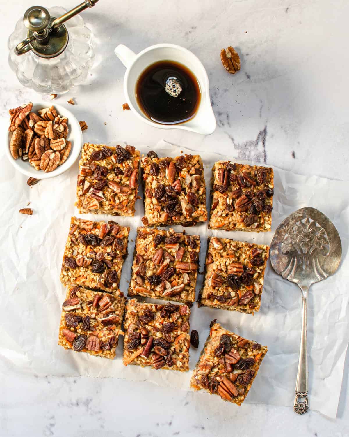 An overhead shot of baked carrot cake oatmeal cut into squares on a table.