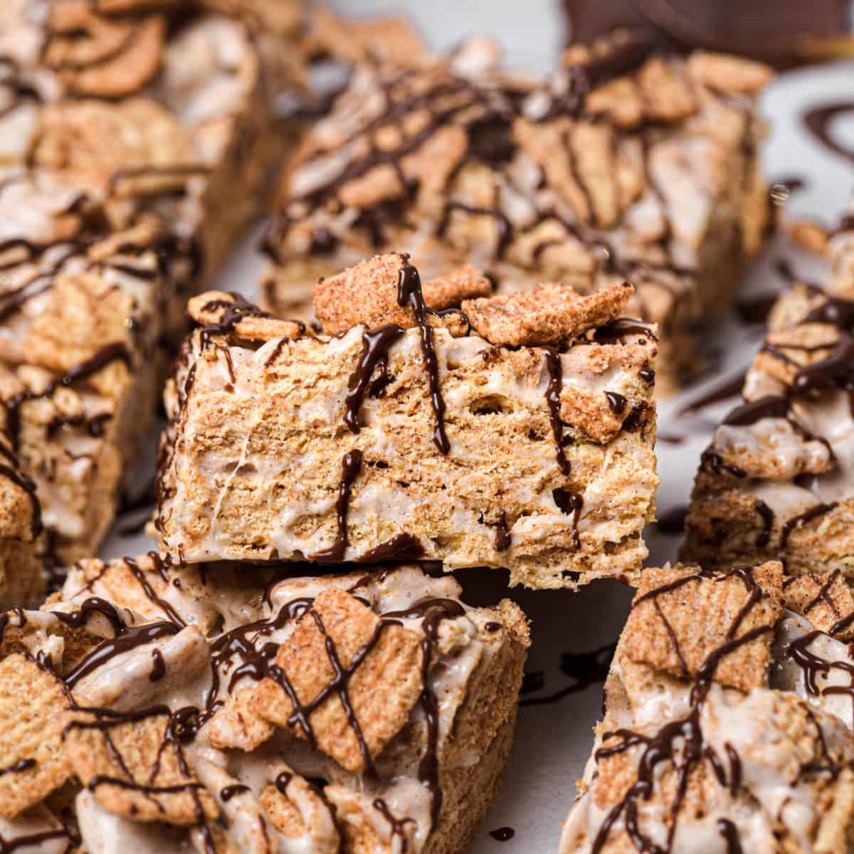 A pile of cinnamon bars on a table ready to eat.