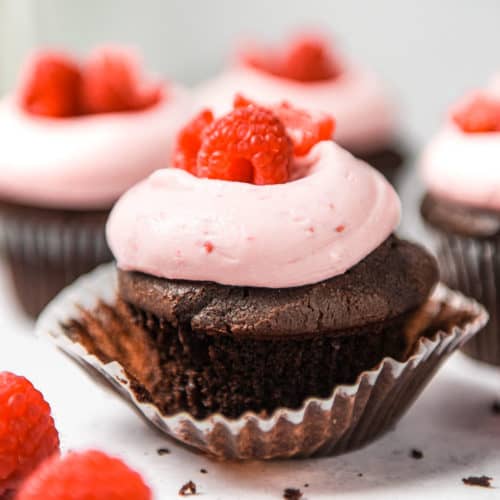 Raspberry chocolate cupcakes on a table.