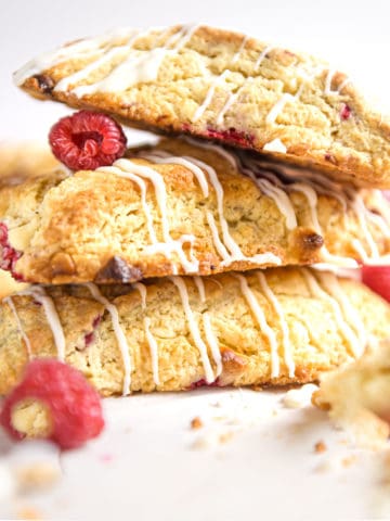 Three raspberry white chocolate scones in a stack.