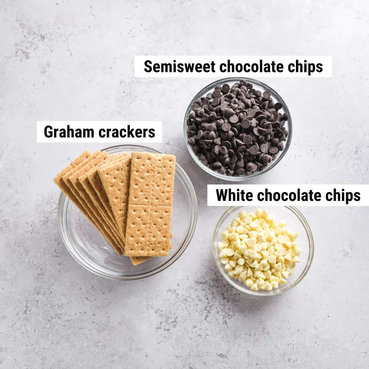 The ingredients to make chocolate covered graham crackers spread out on a table.