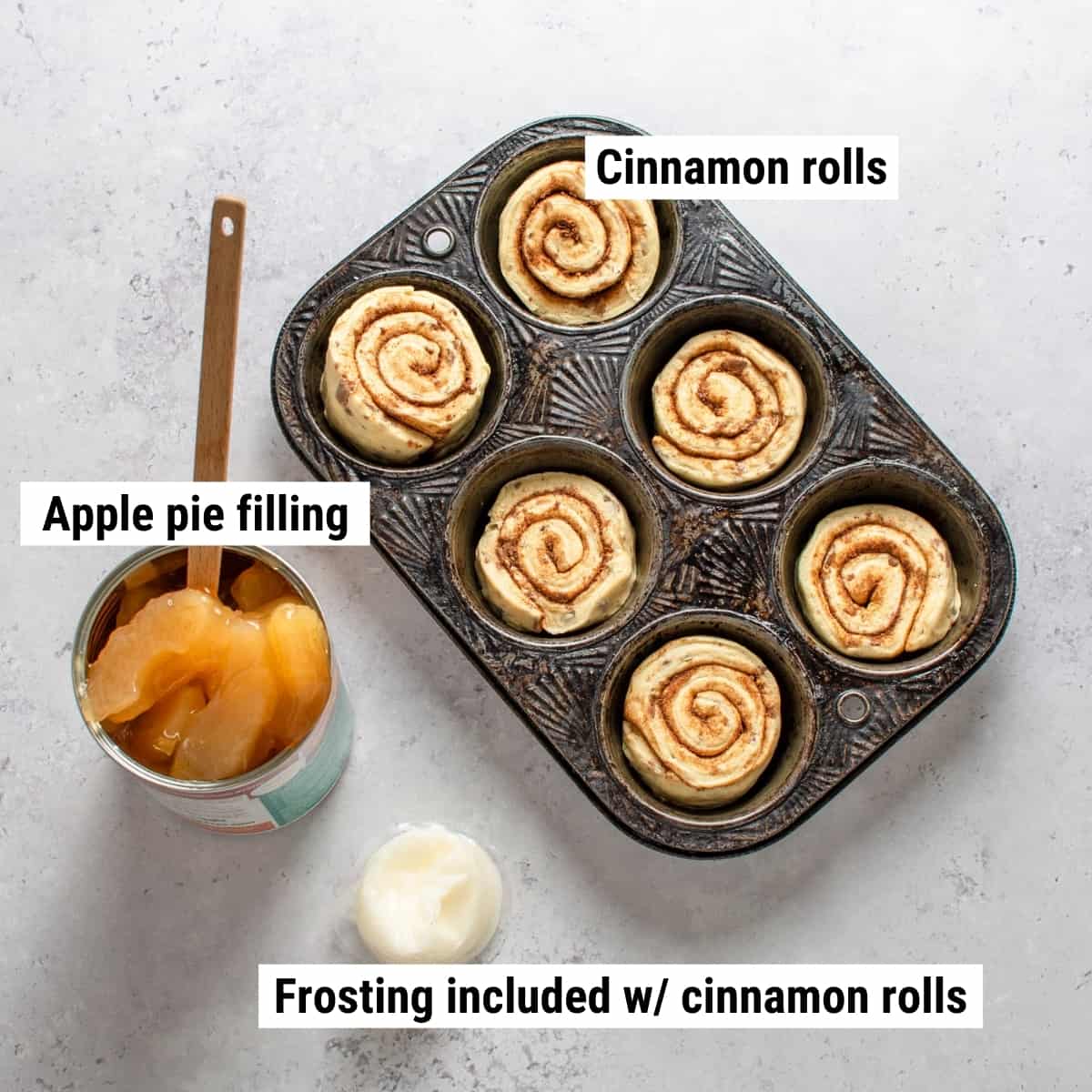 The ingredients used to make cinnamon roll apple pie cups spread out on a table.