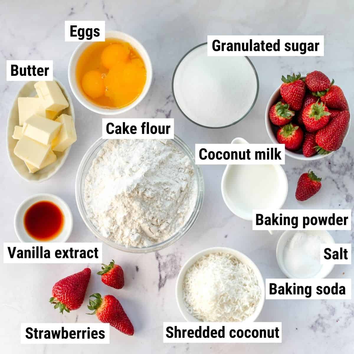 The ingredients to make coconut strawberry cake laid out on a table.