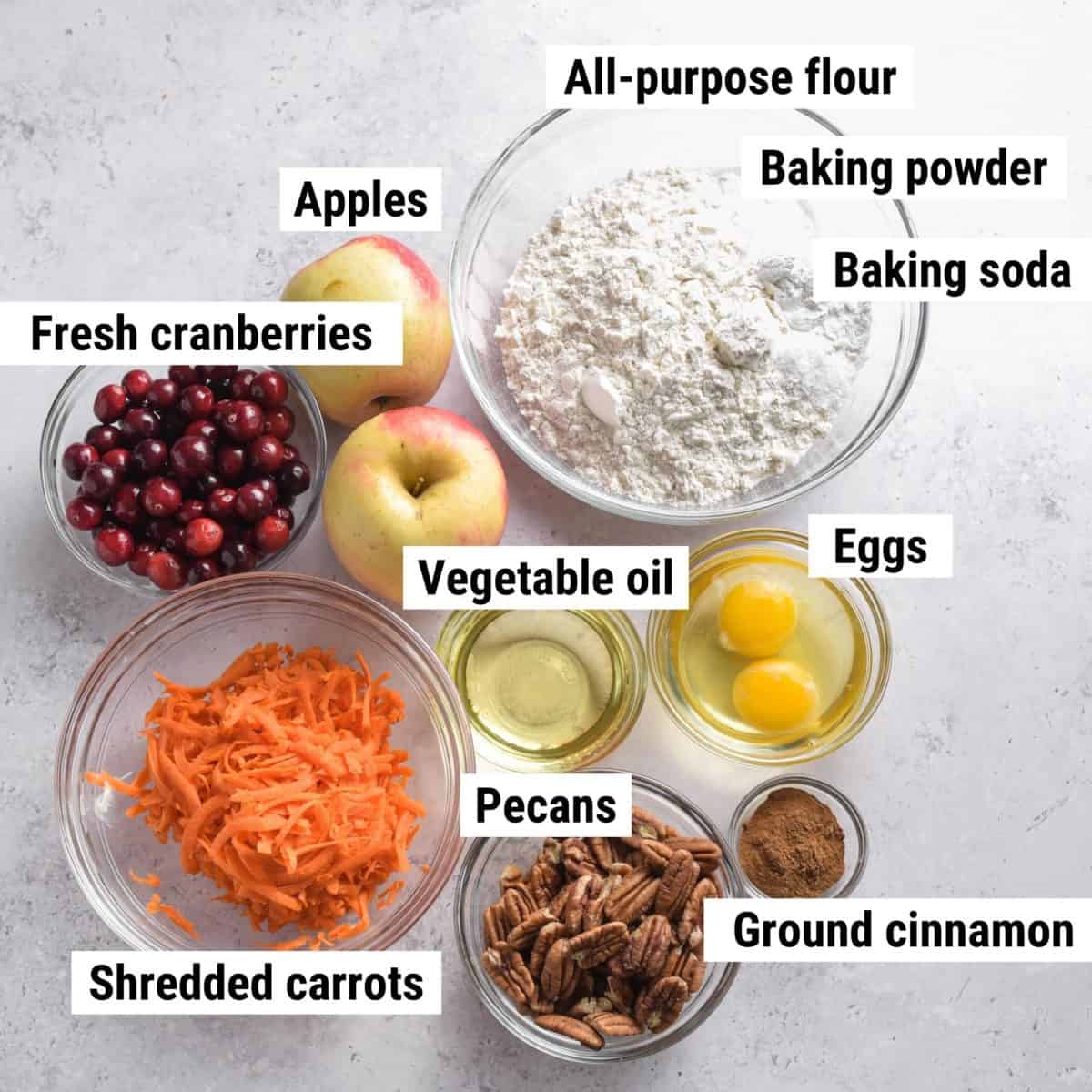 The ingredients used to make apple cranberry muffins laid out on a table.