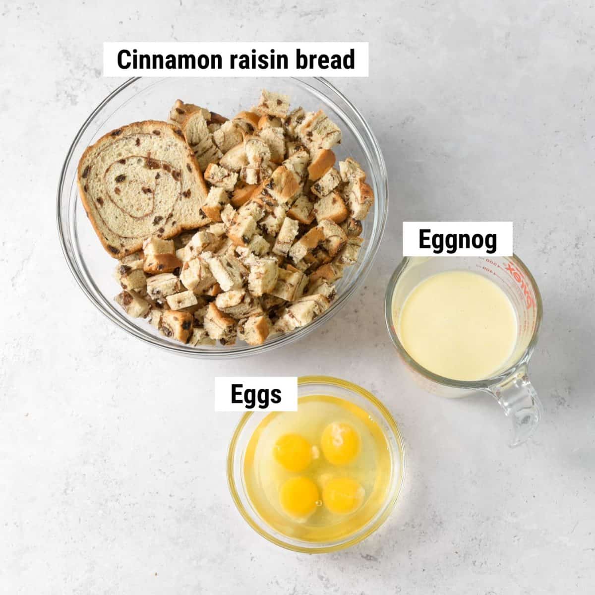 The ingredients used to make eggnog bread pudding spread out on a table.
