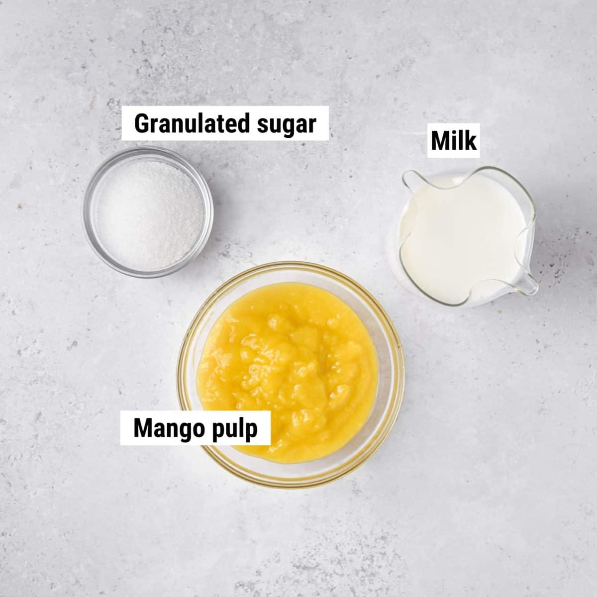 The ingredients used to make mango milkshakes laid out on a table.