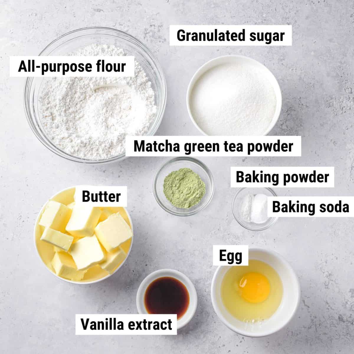 The ingredients used to make matcha cookies spread out on a table.