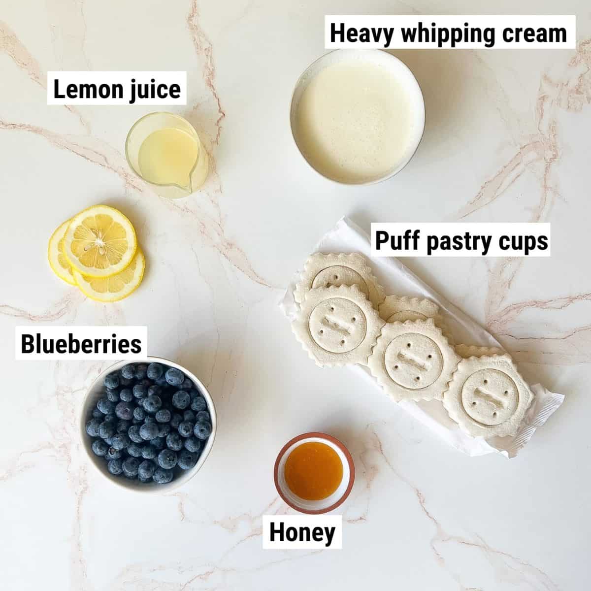 The recipe ingredients used to make puff pastry cups spread out on a table.