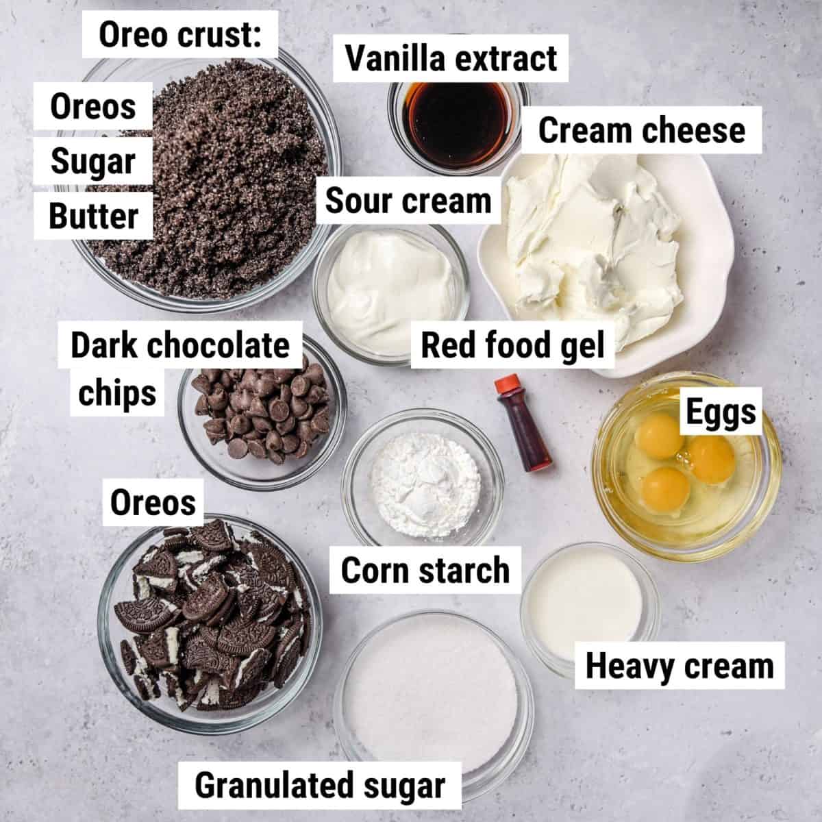 The recipe ingredients to make red velvet Oreo cheesecake spread out on a table.
