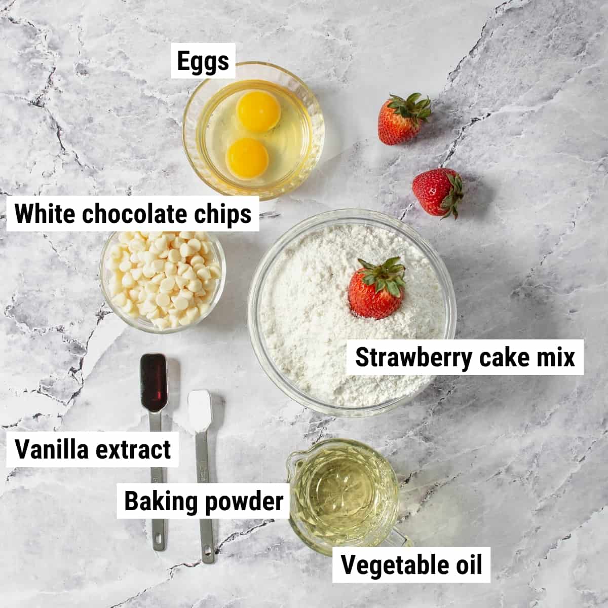The ingredients to make strawberry cake cookies spread out on a table.