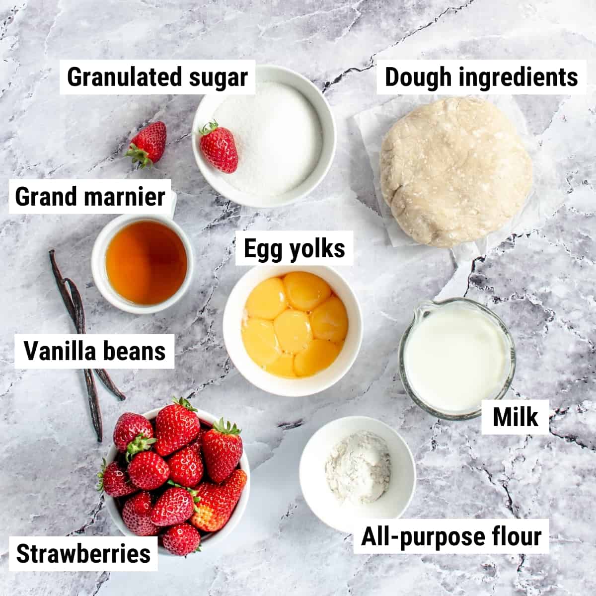 The ingredients used to make strawberry custard tart laid out on a table.