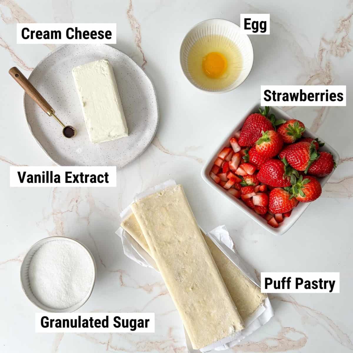 The ingredients used to make strawberry Danishes laid out on a table.
