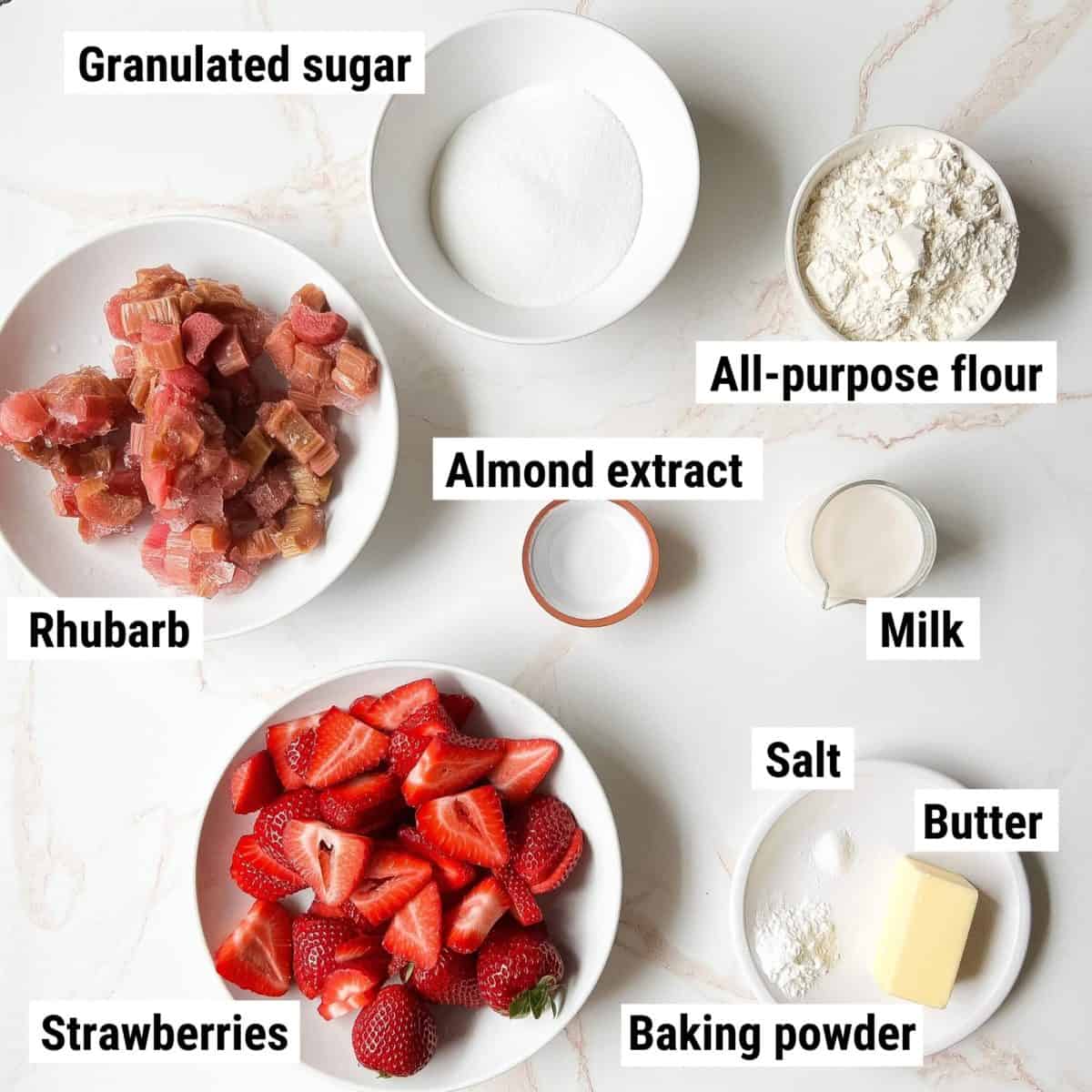 The recipe ingredients used to make strawberry rhubarb cobbler spread out on a table.