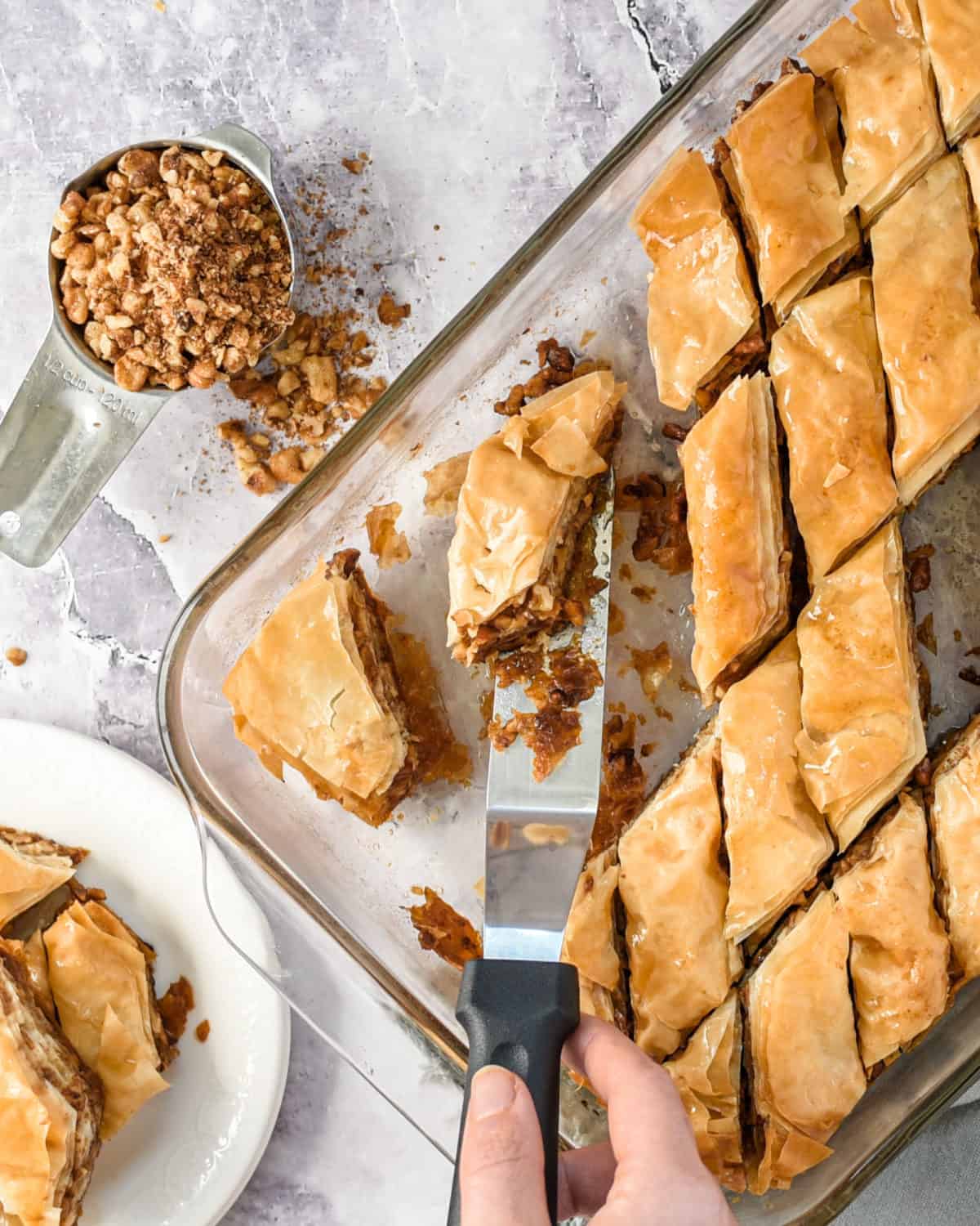 Serving baklava with a serving knife from the baking dish.