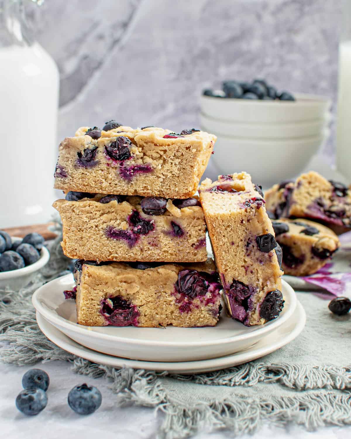 Four blueberry blondies stacked on top of each other.