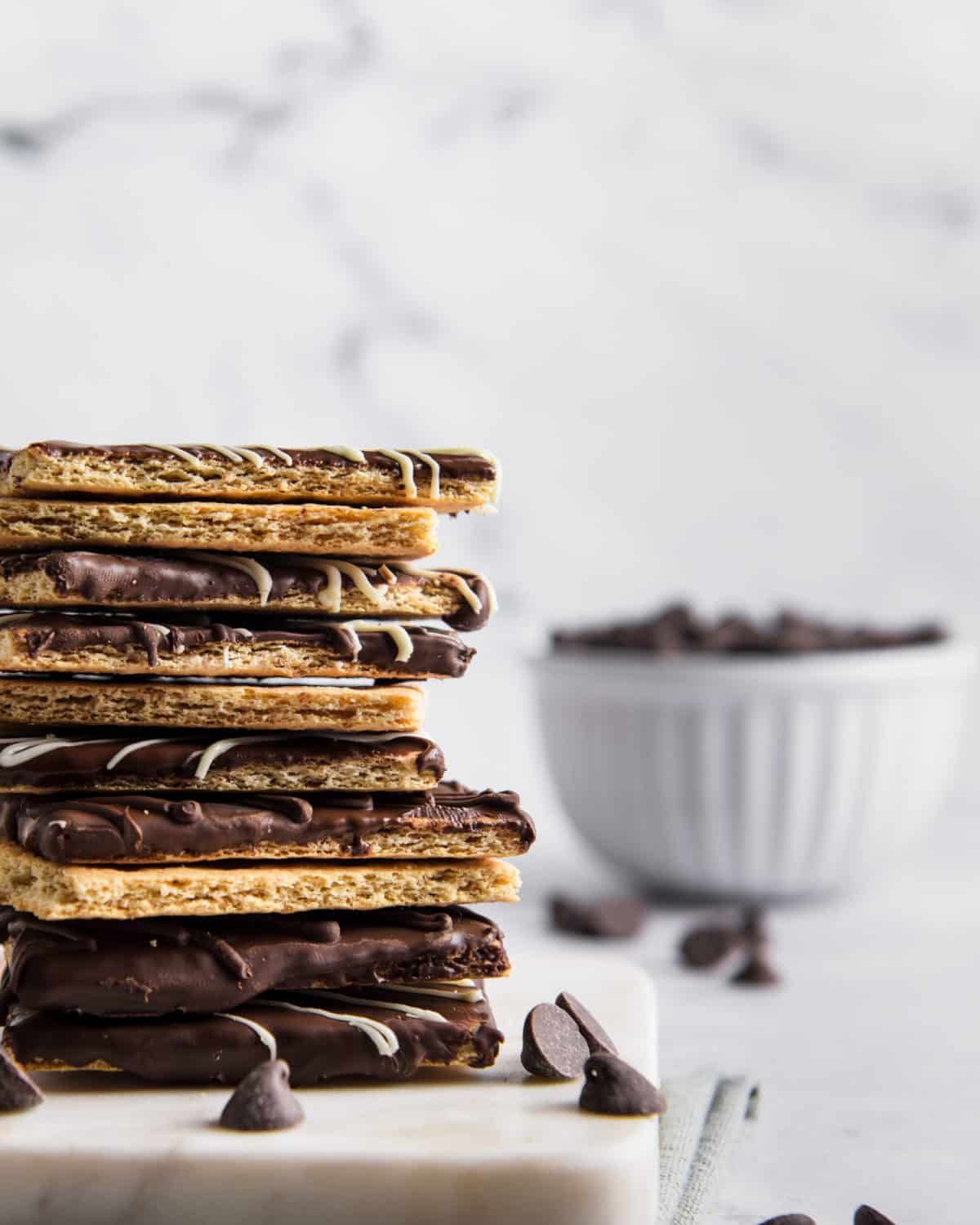 A stack of chocolate covered graham crackers on a table.