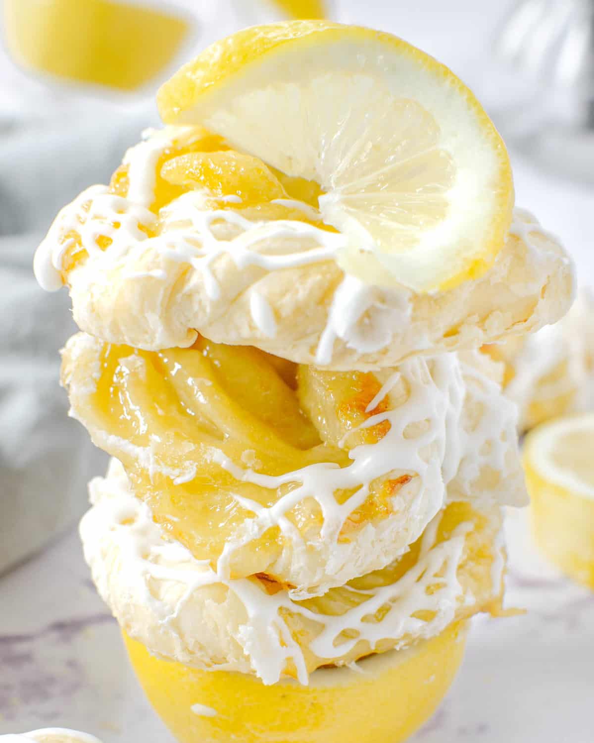 Three lemon curd puff pastries stacked on top of each other.