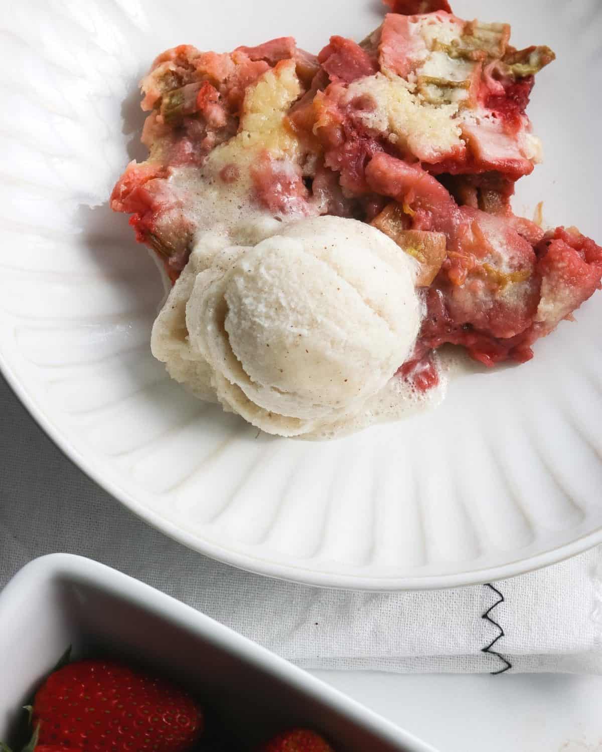 An overhead shot of strawberry cobbler and rhubarb with ice cream.