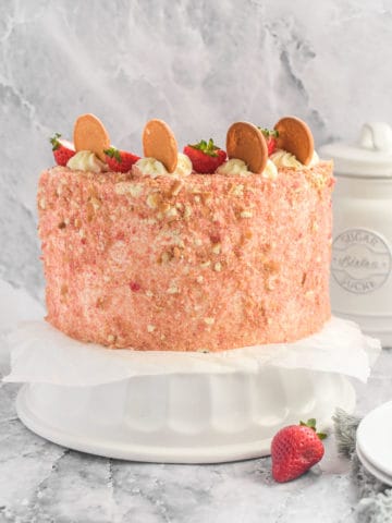 A strawberry crunch cake on a stand.