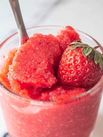 Frozen granita topped with a fresh strawberry.
