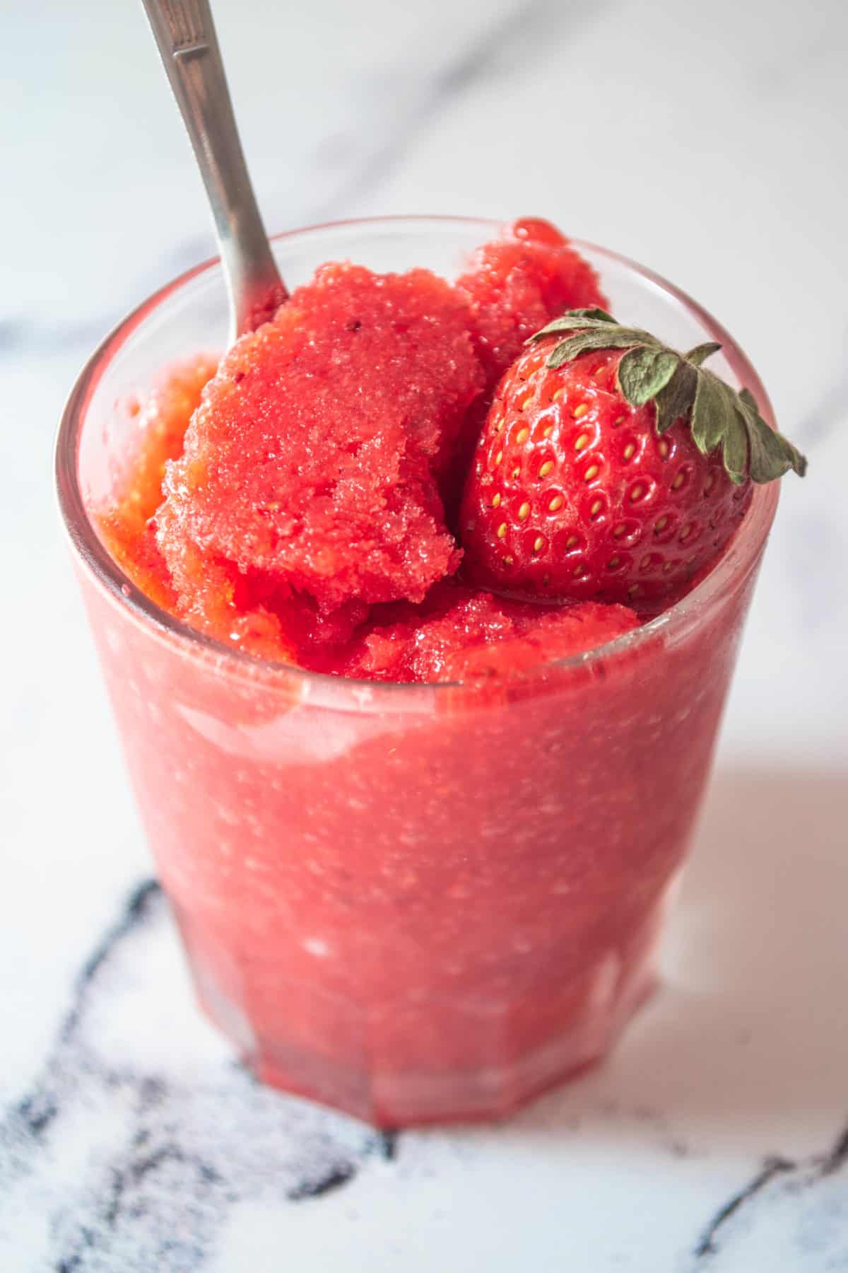 Granita in a glass topped with a strawberry.