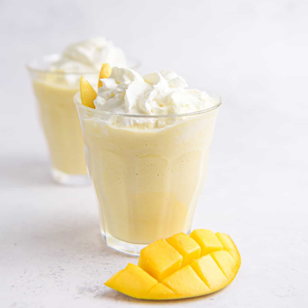 A close up shot of a mango milkshake.