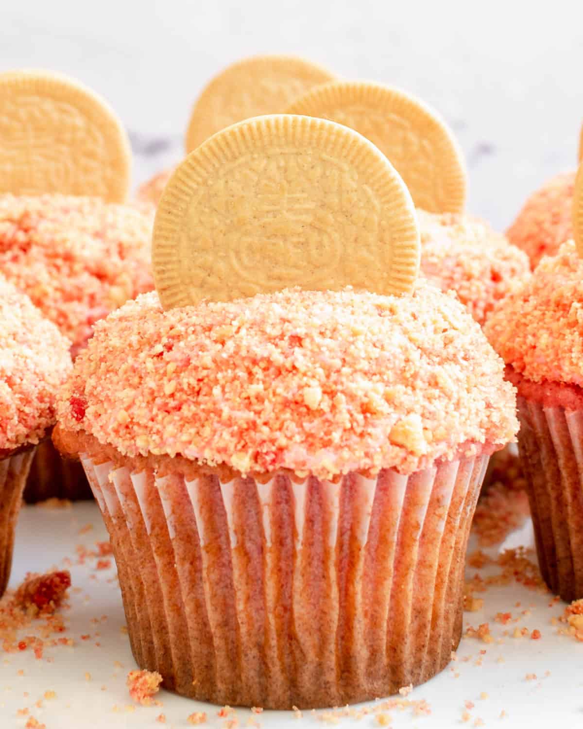 A strawberry cupcake up close with crunch topping.