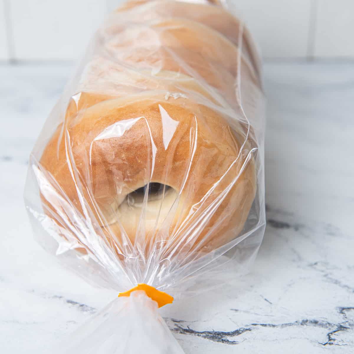 Bagels in a plastic bag on a kitchen counter.