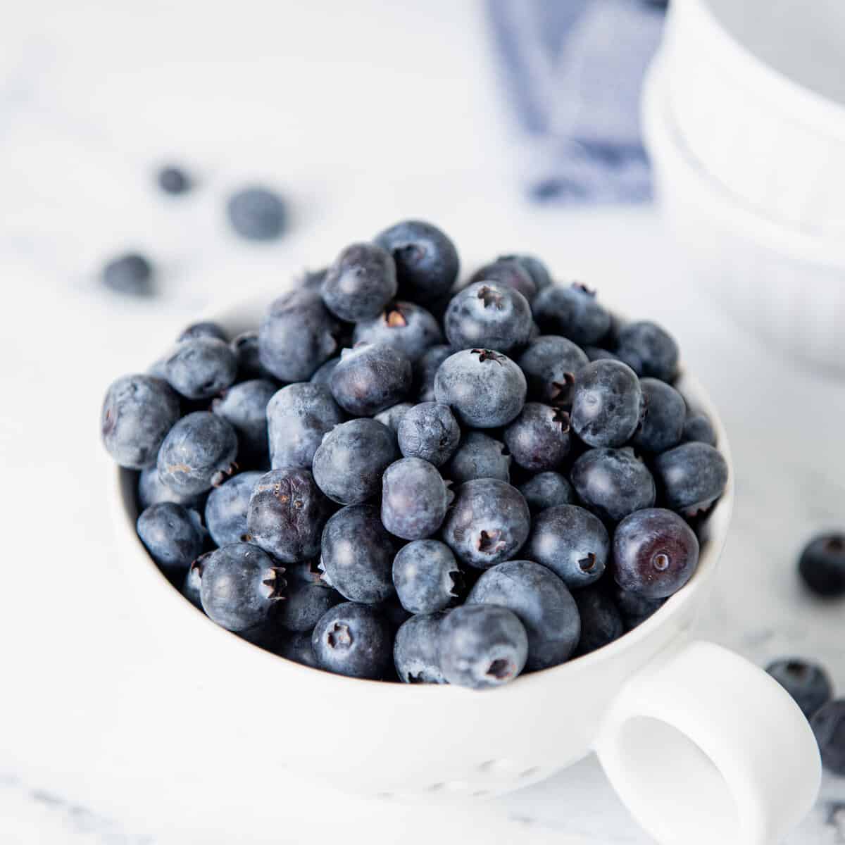 Close-up view of blueberries in a white bowl.