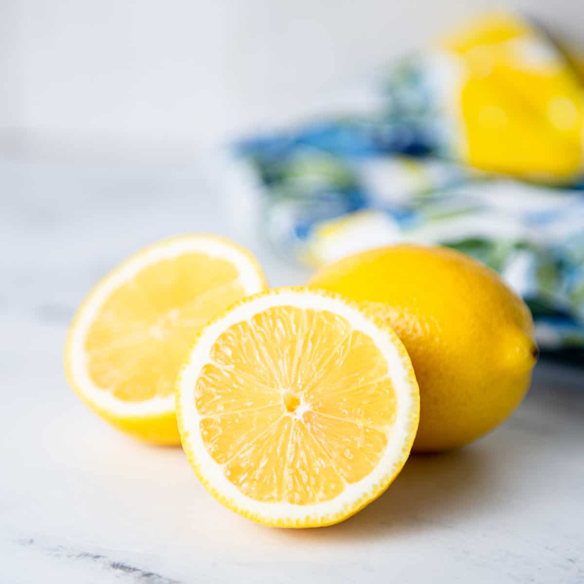 Cut lemons on a kitchen counter with a towel.