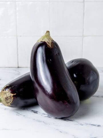 Two eggplant on a counter.