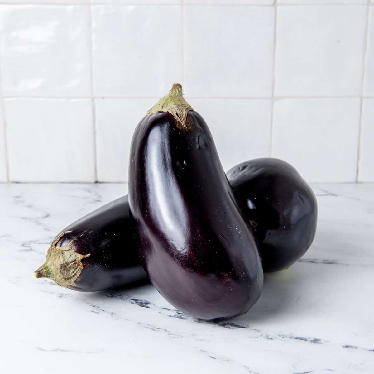 Two eggplant on a counter.