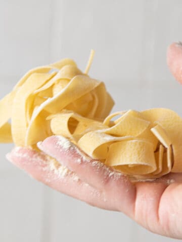 Fresh pasta in a hand with flour.