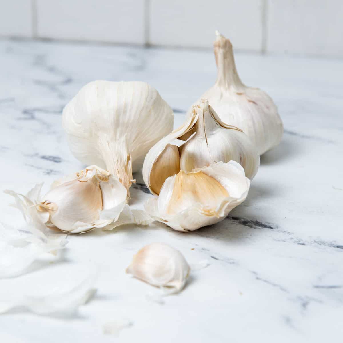 Garlic bulbs and cloves on counter top.