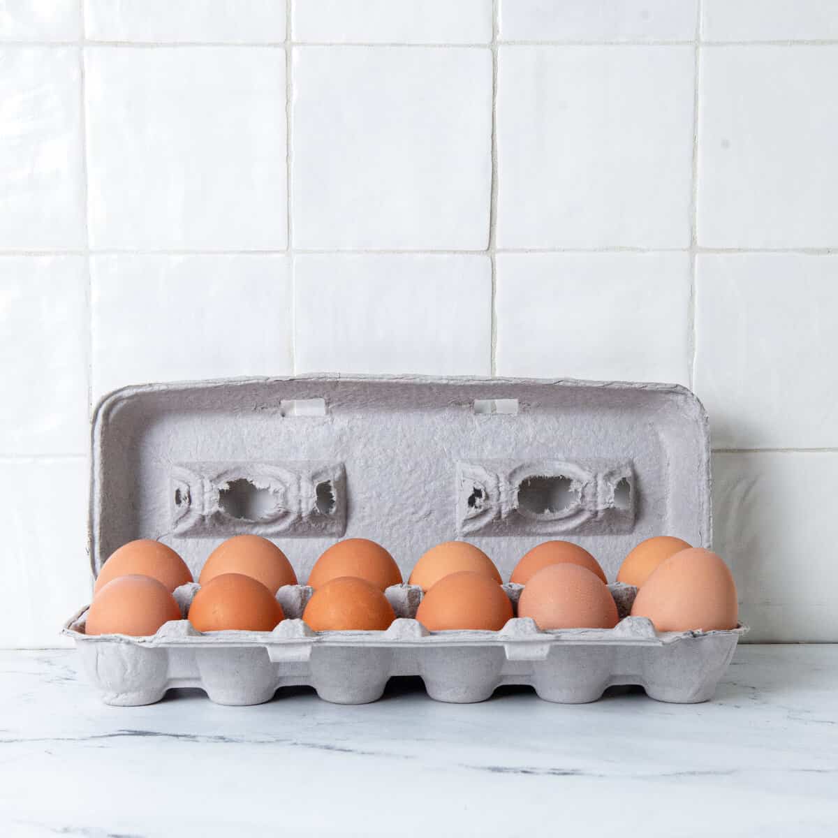 12 hardboiled eggs stored in grey egg carton.