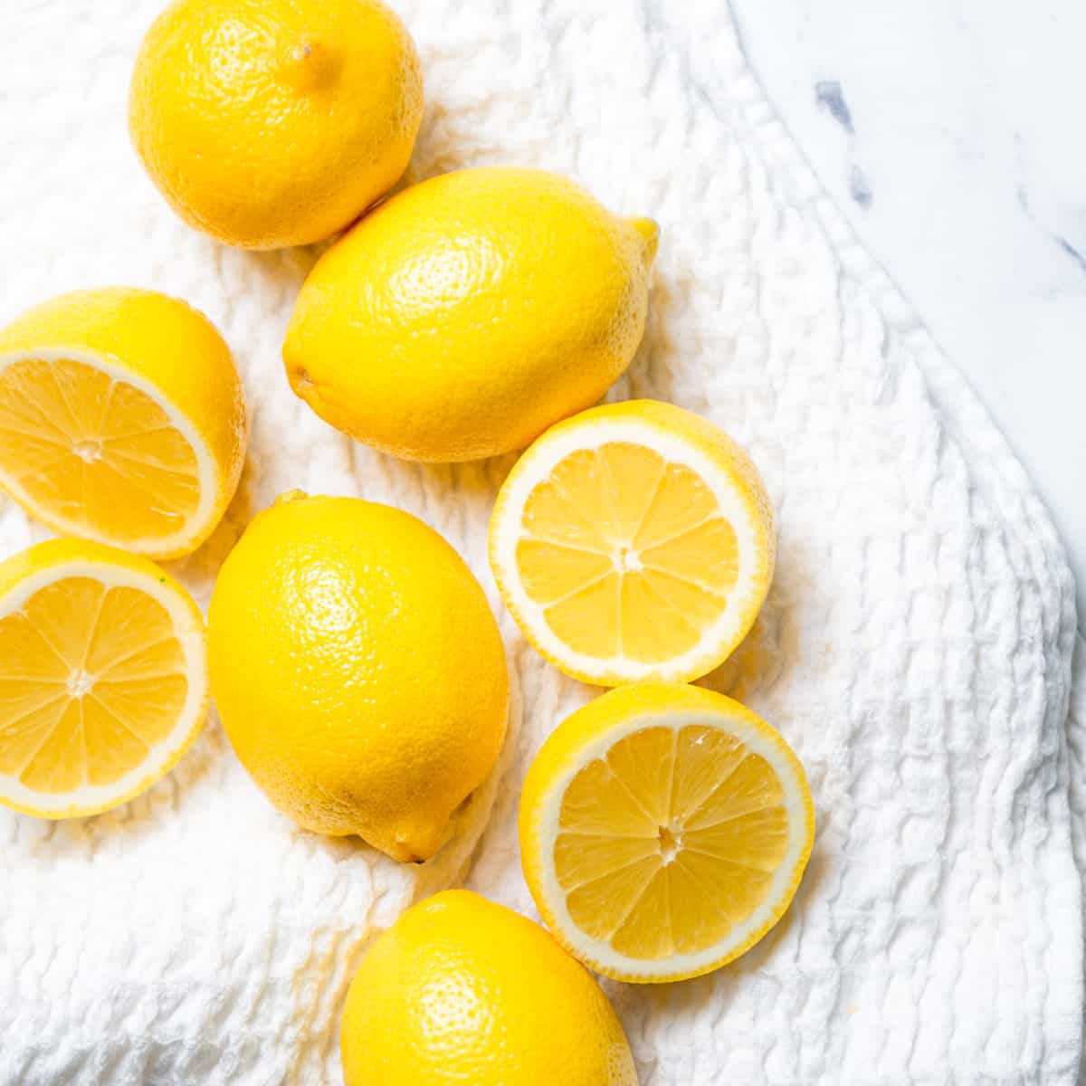 Lemons on a white dish cloth.