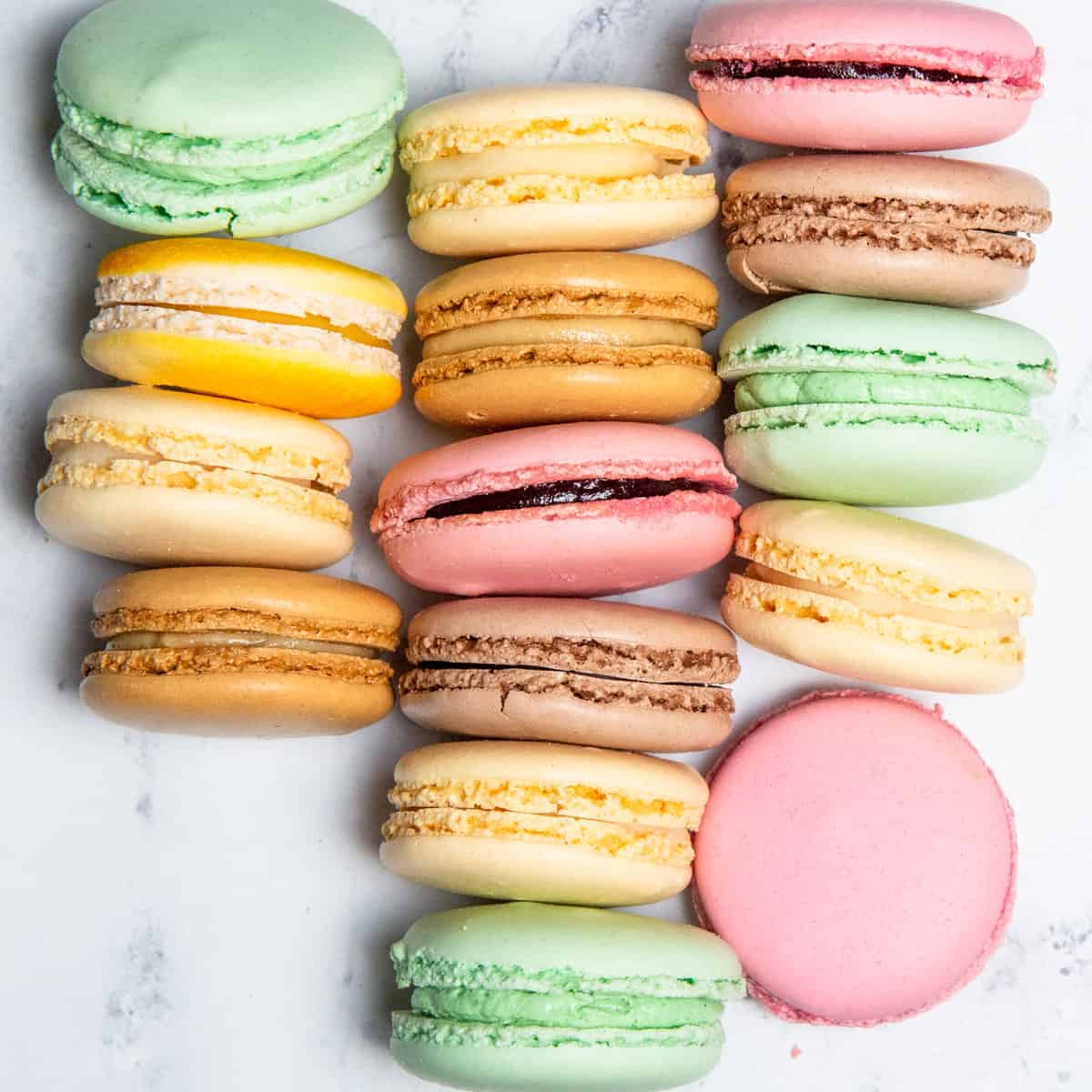 Multicolored macarons placed on a kitchen counter.