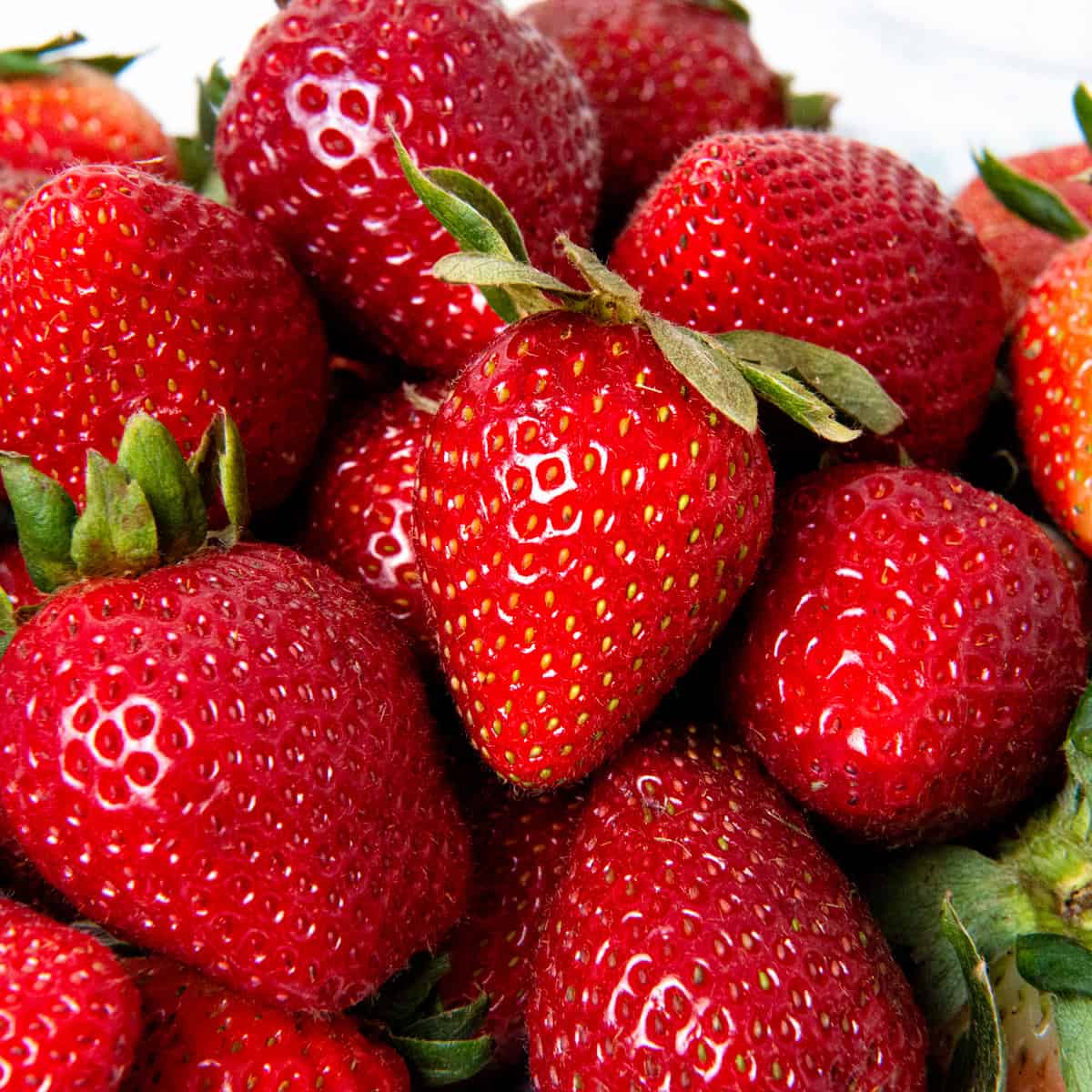 Up close image of a pile of strawberries.