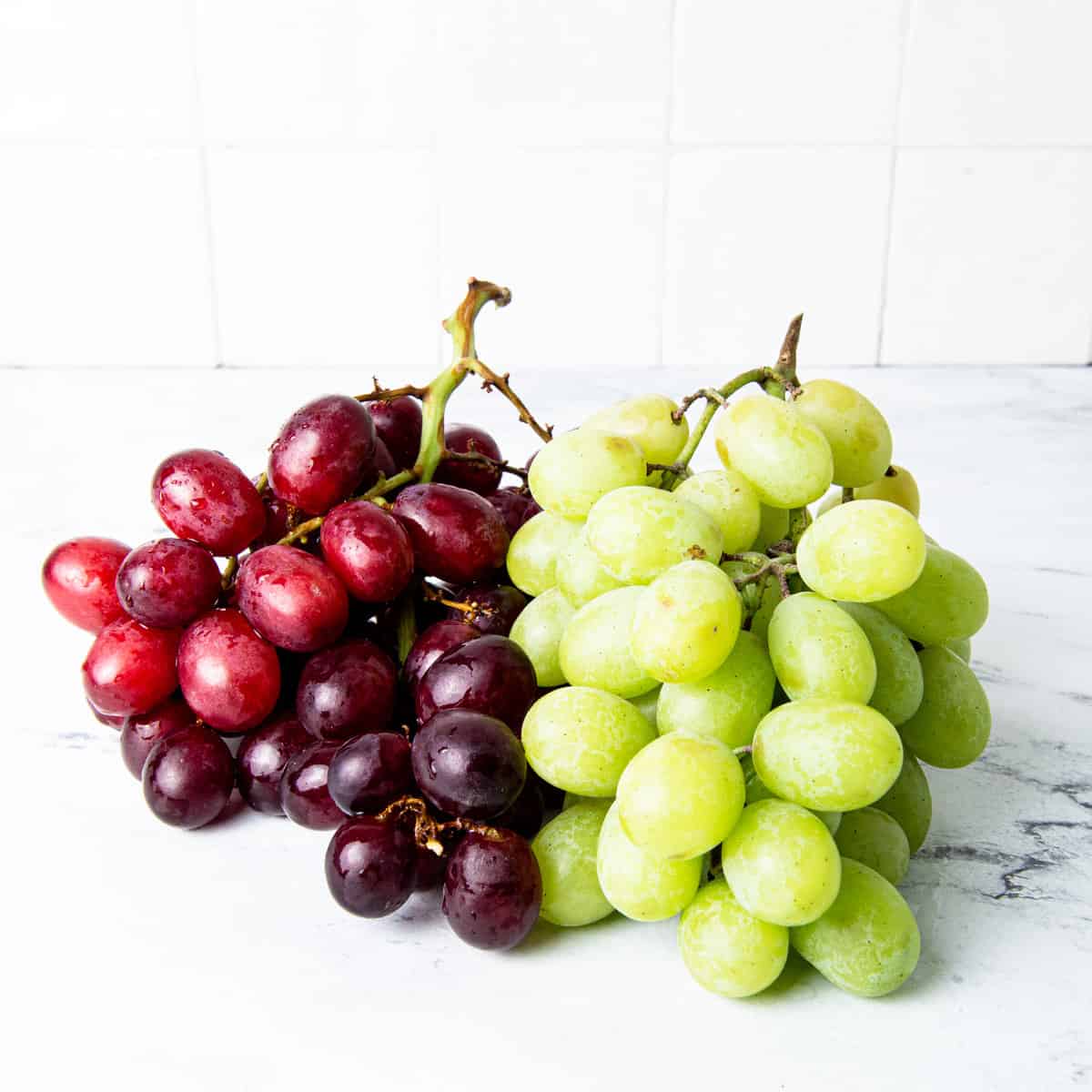 Red and green grapes on the counter.