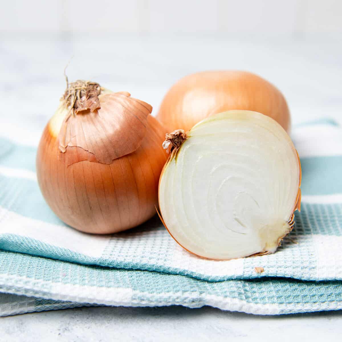 Sliced onion on a blue and white towel.