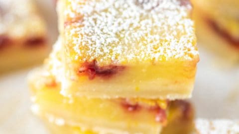 A close up of strawberry lemon bars topped with sugar.