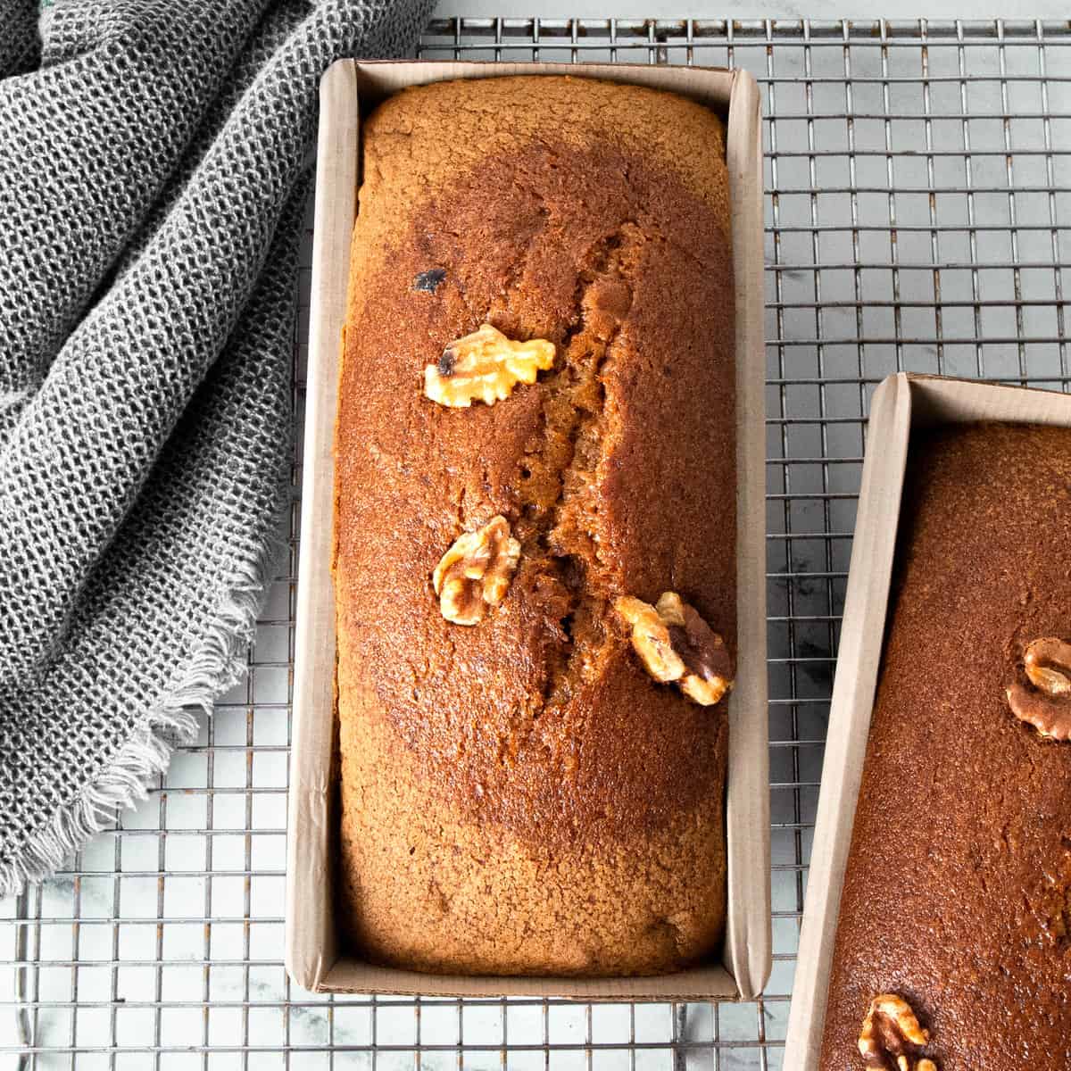 Two banana bread loaves on a cooling rack.